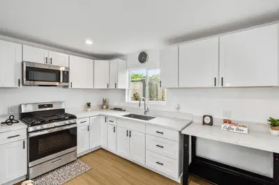 a white kitchen with white cabinets and a sink at Brand New home in San Diego 3BR Quiet neighborhood near Downtown/Seaworld/Zoo in San Diego