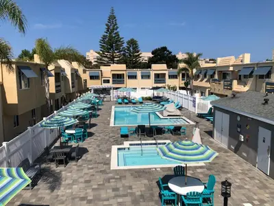an outdoor swimming pool with umbrellas and tables at Amazing Location - Large and Luxurious 1 Bedroom Beach Condo By Beaches and Attractions in Solana Beach