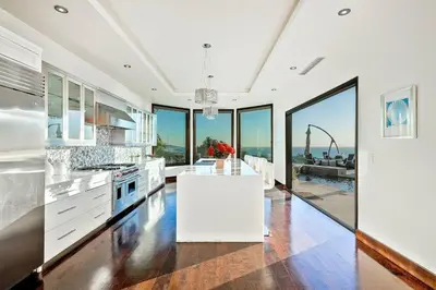 a kitchen with white counters and large windows at Ocean View Serenity with Theater and Heated Pool in San Diego