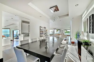 a dining room with a black table and chairs at Ocean View Serenity with Theater and Heated Pool in San Diego