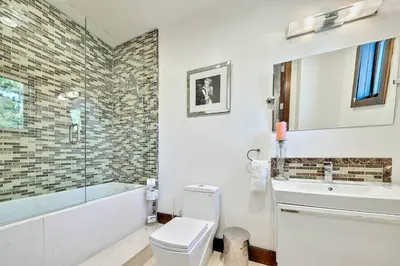 a bathroom with a toilet and a tub and a sink at Ocean View Serenity with Theater and Heated Pool in San Diego