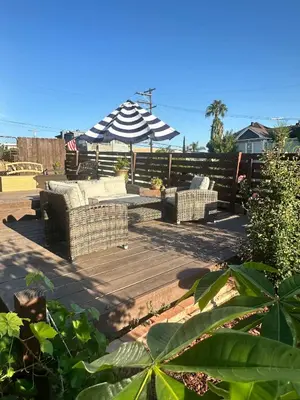 a patio with two couches and an umbrella at Charming Guest House in SD in San Diego