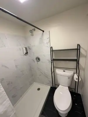 a white bathroom with a toilet and a shower at Charming Guest House in SD in San Diego