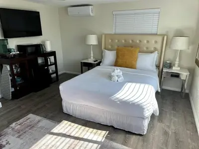 a bedroom with a white bed with a teddy bear on it at Charming Guest House in SD in San Diego