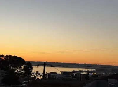 a sunset over a body of water with a city at Guest House next to Little Italy in San Diego