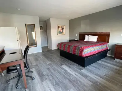 a hotel room with a bed and a desk at CoachLight Motel in Hemet