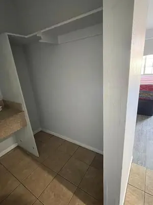 an empty room with a shelf and a tile floor at CoachLight Motel in Hemet