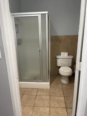 a bathroom with a shower and a toilet at CoachLight Motel in Hemet