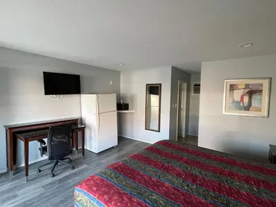 a hotel room with a bed and a flat screen tv at CoachLight Motel in Hemet