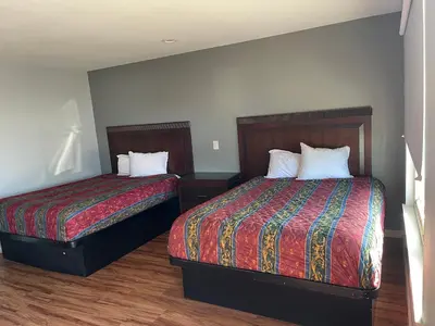 two beds in a small room with two beds sidx sidx sidx at CoachLight Motel in Hemet