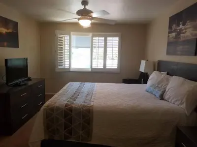 a bedroom with a bed with a ceiling fan and a television at Sand Pebbles Resort - 1 Bedroom Condo in Great Location Right by the Beaches and Attractions in Solana Beach