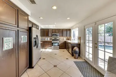 a kitchen with a refrigerator and a stove top oven at Lake Elsinore Home with Pool - 44 Mi to Disneyland! in Lake Elsinore