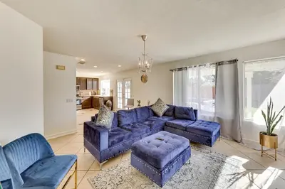 a living room with a blue couch and chairs at Lake Elsinore Home with Pool - 44 Mi to Disneyland! in Lake Elsinore