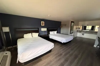 a bedroom with two beds and a black wall at Travelodge by Wyndham Hemet CA in Hemet