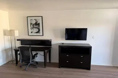 a room with a desk and a television and a desk with a computer at Travelodge by Wyndham Hemet CA in Hemet