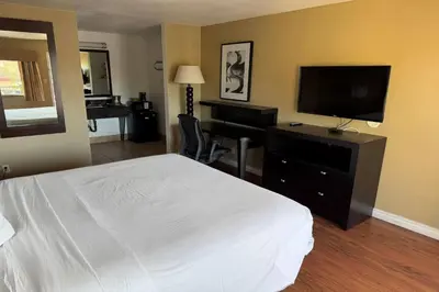 a hotel room with a bed and a flat screen tv at Travelodge by Wyndham Hemet CA in Hemet