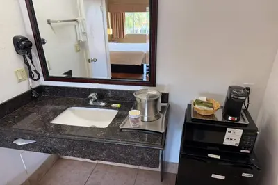 a hotel bathroom with a sink and a mirror at Travelodge by Wyndham Hemet CA in Hemet