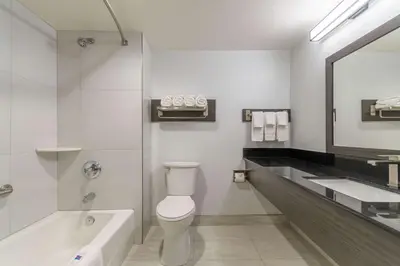 a bathroom with a toilet and a sink and a tub at Studio 6 Suites Perris, CA in Perris