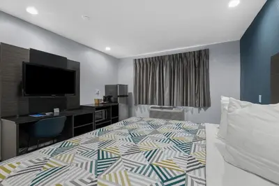 a hotel room with a bed and a desk at Studio 6 Suites Perris, CA in Perris