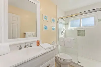 a white bathroom with a sink and a toilet at Oceanfront 3-unit complex - Private Deck - BBQ in Oceanside