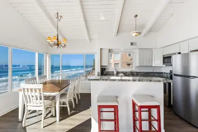 a kitchen with a table and chairs and the ocean at Oceanfront 3-unit complex - Private Deck - BBQ in Oceanside