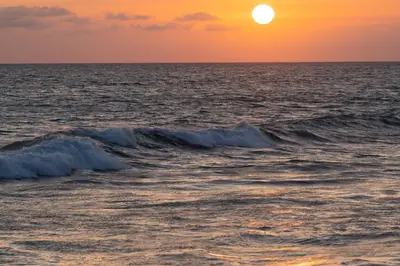 a sunset over the ocean with waves at 2BR Oceanfront Condo - Private Balcony - Spacious in Oceanside