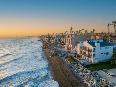 a group of houses on a beach next to the ocean at 2BR Oceanfront Condo - Private Balcony - Spacious in Oceanside