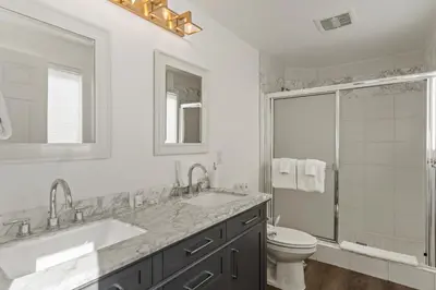 a white bathroom with two sinks and a toilet at Romantic Getaway - Luxury Oceanfront Studio - Private Balcony - Fireplace in Oceanside