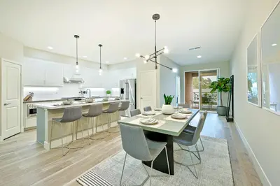 a kitchen and dining room with a table and chairs at Modern 4BR - Private Balcony - Garage Parking in Carlsbad