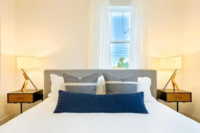 a bedroom with a white bed with two lamps at Modern 4BR - Private Balcony - Garage Parking in Carlsbad