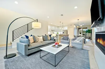 a living room with a couch and a fireplace at Modern 4BR - Private Balcony - Garage Parking in Carlsbad