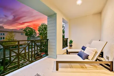 a balcony with a couch and a sunset at Modern 4BR - Private Balcony - Garage Parking in Carlsbad