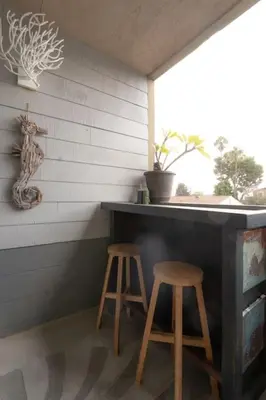 a bar with two stools next to a window at Not taking reservations in Chula Vista