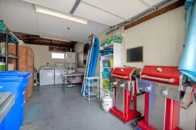 a garage with a room with a surfboard on the wall at Walk To Beach - EV Charger - Outdoor Dining - 2BR in Carlsbad