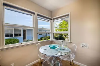 a dining room with a table and chairs and windows at Walk To Beach - EV Charger - Outdoor Dining - 2BR in Carlsbad