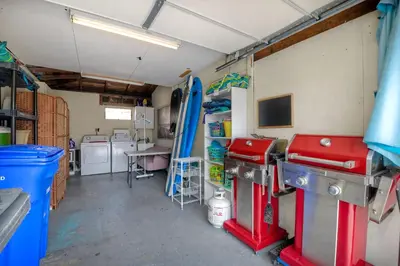 a garage with a room with surfboards on the wall at Walk To Beach - EV Charger - Outdoor Dining - 2BR in Carlsbad
