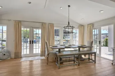 a dining room with a table and chairs and windows at Walk To Beach & Village - 5 Bedrooms - 3 Units in Carlsbad