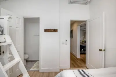 a white bedroom with a door leading to a bathroom at Walk To Beach & Village - 5 Bedrooms - 3 Units in Carlsbad