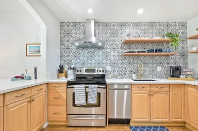 a kitchen with wooden cabinets and a stove top oven at La Costa Escape - Pool, BBQ, Gated Parking in Encinitas