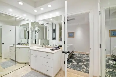 a white bathroom with a sink and a mirror at Private Balcony Overlooking Pool - Gated Parking in Encinitas