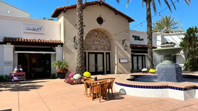 a patio with chairs and a fountain in front of a building at Private Balcony Overlooking Pool - Gated Parking in Encinitas