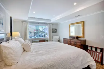a bedroom with a large white bed and a window at 90 Walk Score, Steps to Beach, Dining in Carlsbad