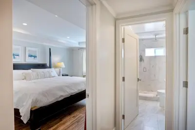 a bedroom with a king sized bed and a bathroom at 90 Walk Score, Steps to Beach, Dining in Carlsbad