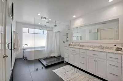 a bathroom with two sinks and a tub and a mirror at Luxury Ocean Views - 6 BR Home - Steps to Sand in Carlsbad