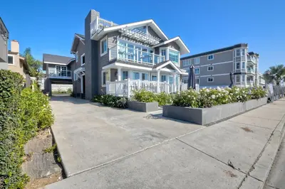 a large house on a street with bushes at Luxury Ocean Views - 6 BR Home - Steps to Sand in Carlsbad