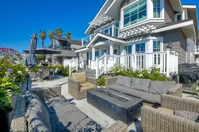 a house with a patio with a couch and chairs at Luxury Ocean Views - 6 BR Home - Steps to Sand in Carlsbad