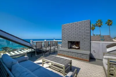 a living room with a blue couch and a fireplace at Luxury Ocean Views - 6 BR Home - Steps to Sand in Carlsbad