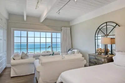 a bedroom with a bed and two couches and a window at Juniper Beach Entire Home - Sleeps 18 - Oceanfront in Carlsbad