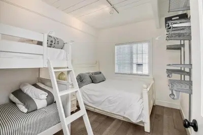 a small bedroom with a bunk bed and a ladder at Juniper Beach Entire Home - Sleeps 18 - Oceanfront in Carlsbad