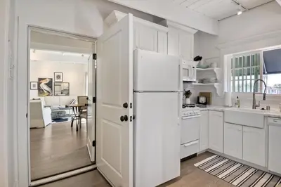 a kitchen with white cabinets and a white refrigerator at Juniper Beach Entire Home - Sleeps 18 - Oceanfront in Carlsbad